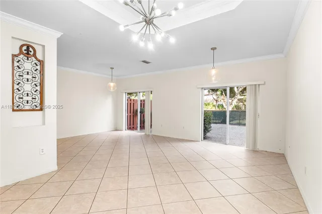an empty room with windows and chandelier fan