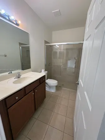 a bathroom with a double vanity sink toilet and shower