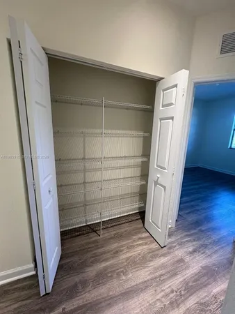 a view of walk in closet with empty racks