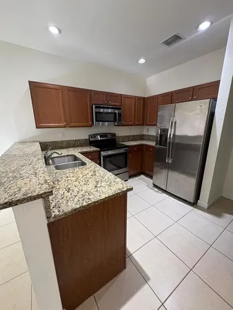 a kitchen with stainless steel appliances granite countertop a refrigerator and a sink