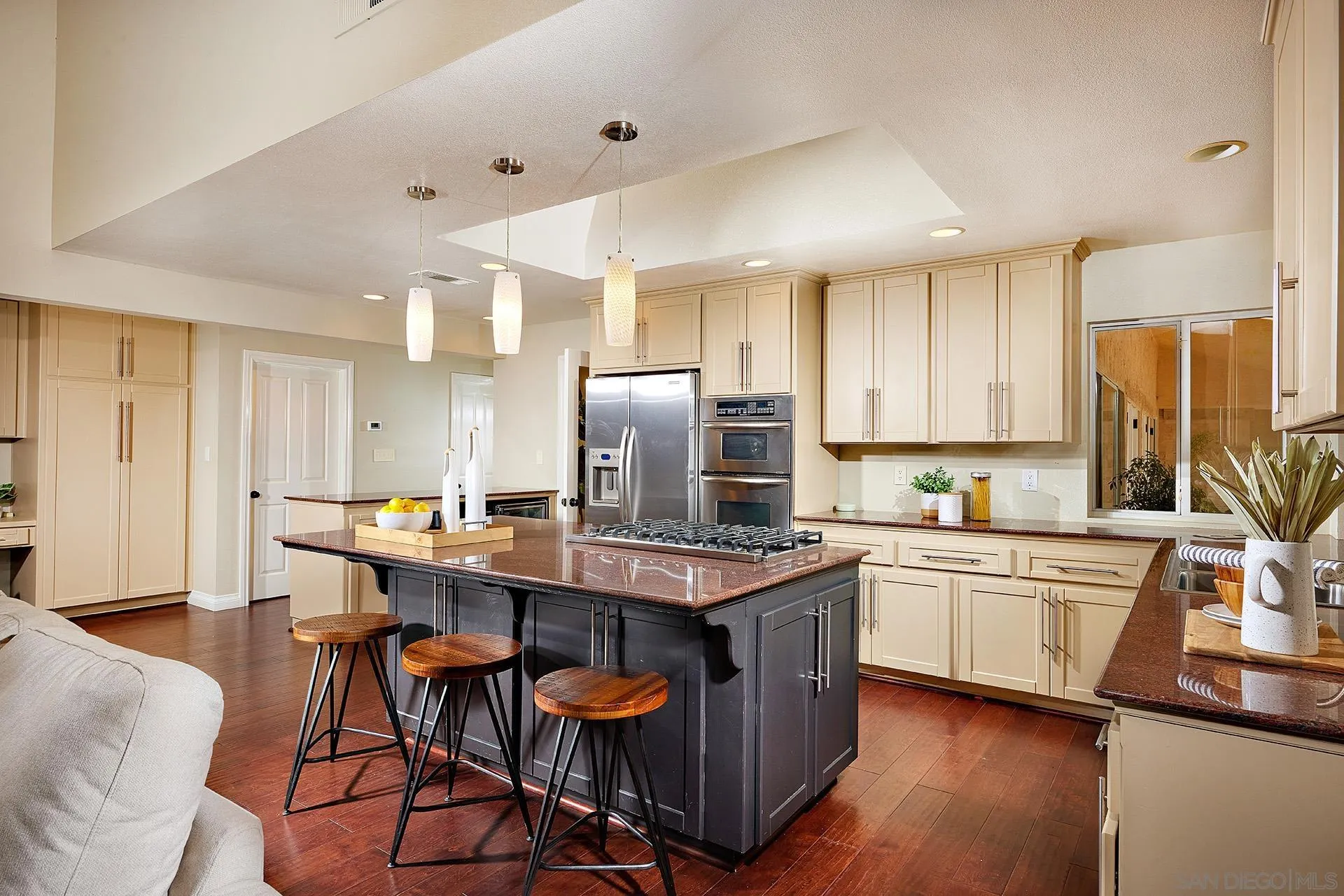 2027 Alga Road Carlsbad, CA 92009 - Photo 28 of 72 a kitchen with stainless steel appliances granite countertop a table chairs sink refrigerator and cabinets