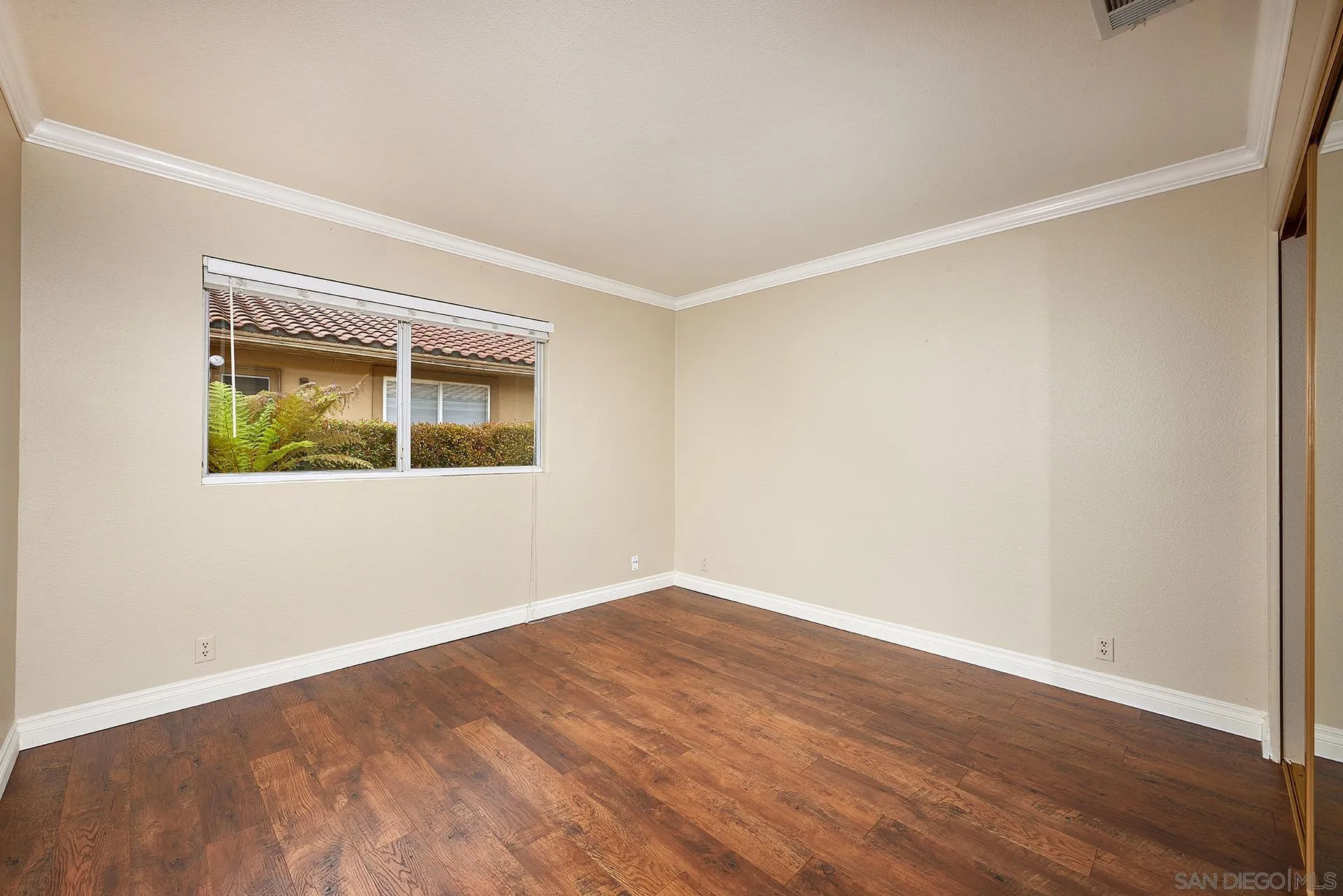 2027 Alga Road Carlsbad, CA 92009 - Photo 40 of 72 a view of an empty room with wooden floor and a window