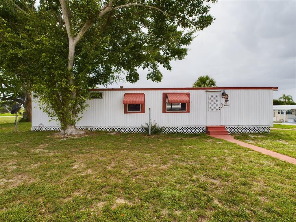 109 Ruby Way Lake Placid, FL 33852 - Photo 1 of 14 a backyard of a house with plants and large trees