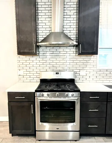 a stove top oven sitting inside of a kitchen