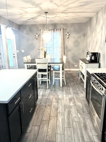 a kitchen with a sink and chairs