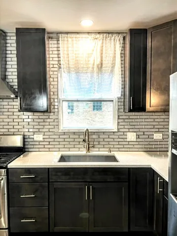 a kitchen with a sink a window and cabinets