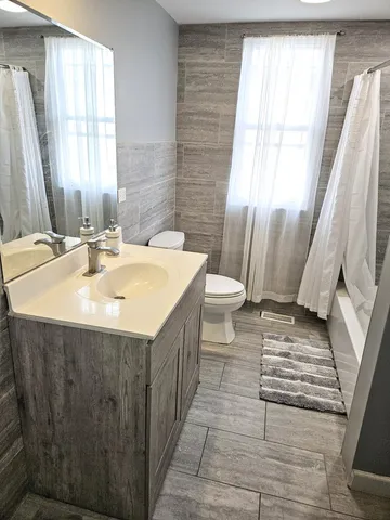 a bathroom with a sink a toilet and a window