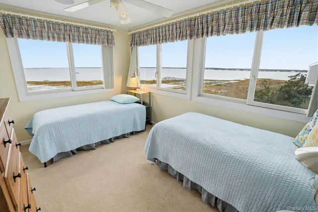 a bedroom with two beds and a large window