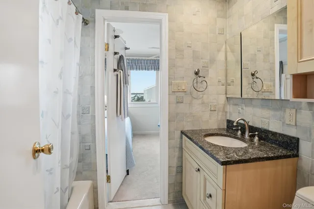 a bathroom with a granite countertop sink and a mirror