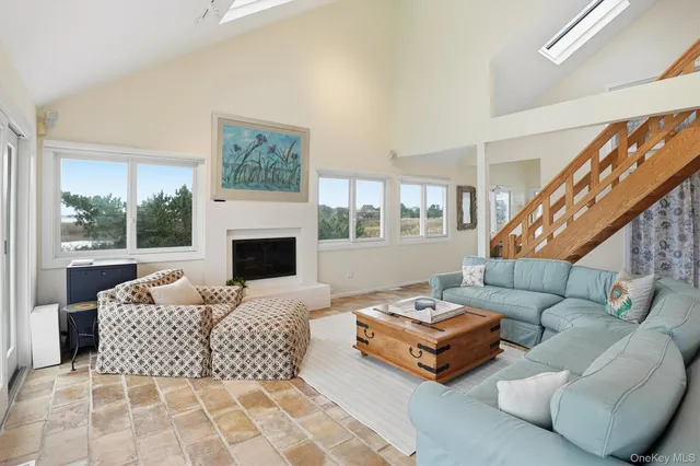 a living room with furniture fireplace and a large window