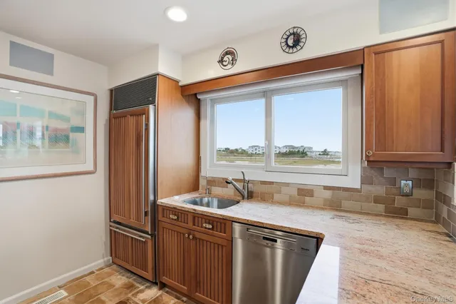 a kitchen with stainless steel appliances granite countertop a refrigerator and a sink