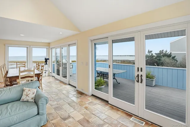 a living room with furniture floor to ceiling window and wooden floor