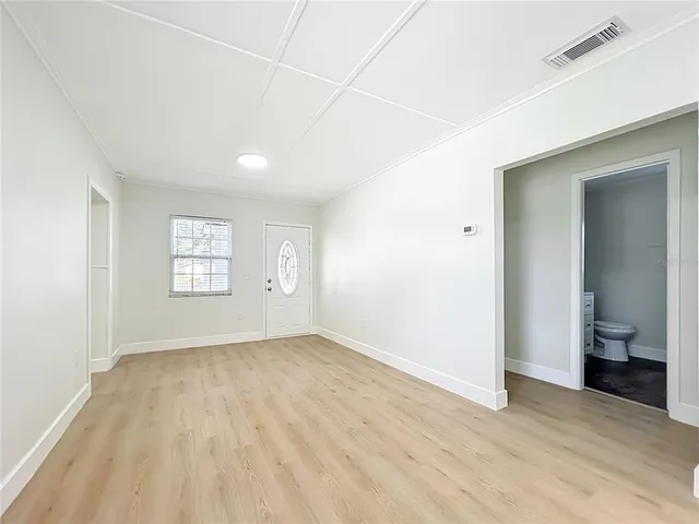an empty room with a white walls and toilet