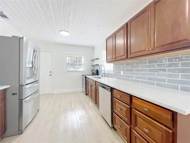 a kitchen with stainless steel appliances granite countertop a refrigerator sink and cabinets