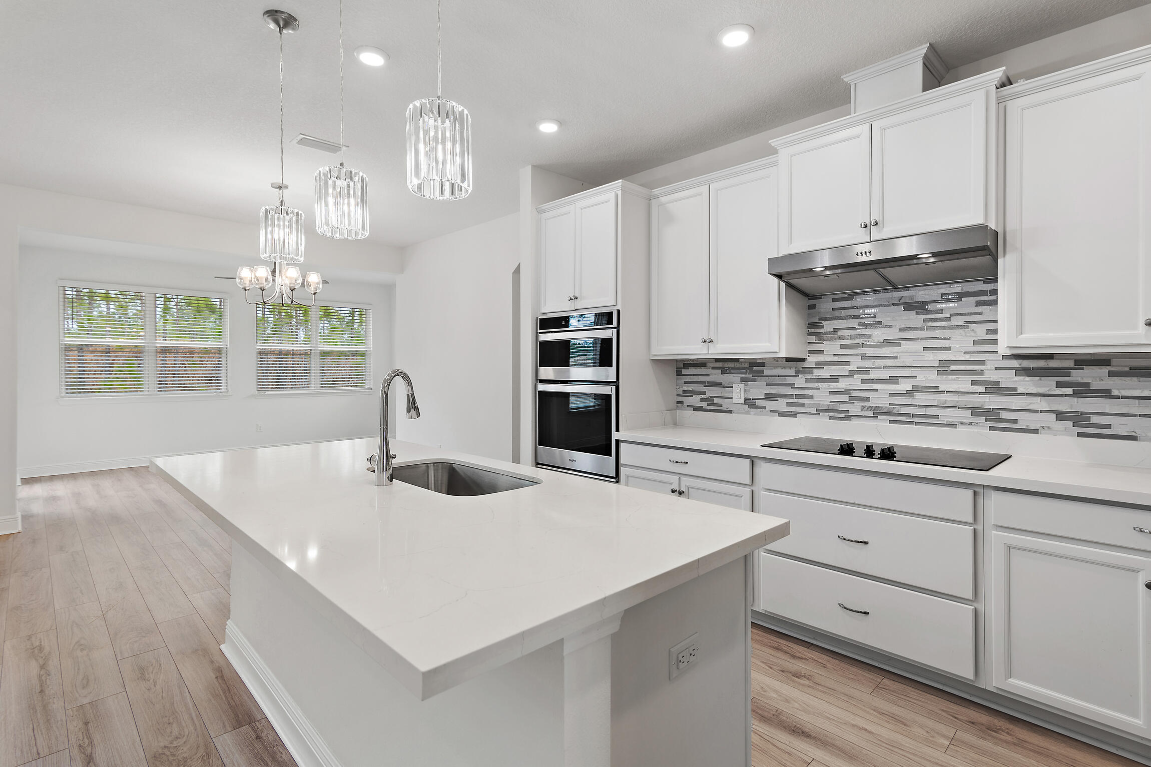 430 Fairway Crossing Freeport, FL 32439 - Photo 14 of 57 a kitchen with stainless steel appliances granite countertop a sink dishwasher a stove a refrigerator and a dining table with wooden floor