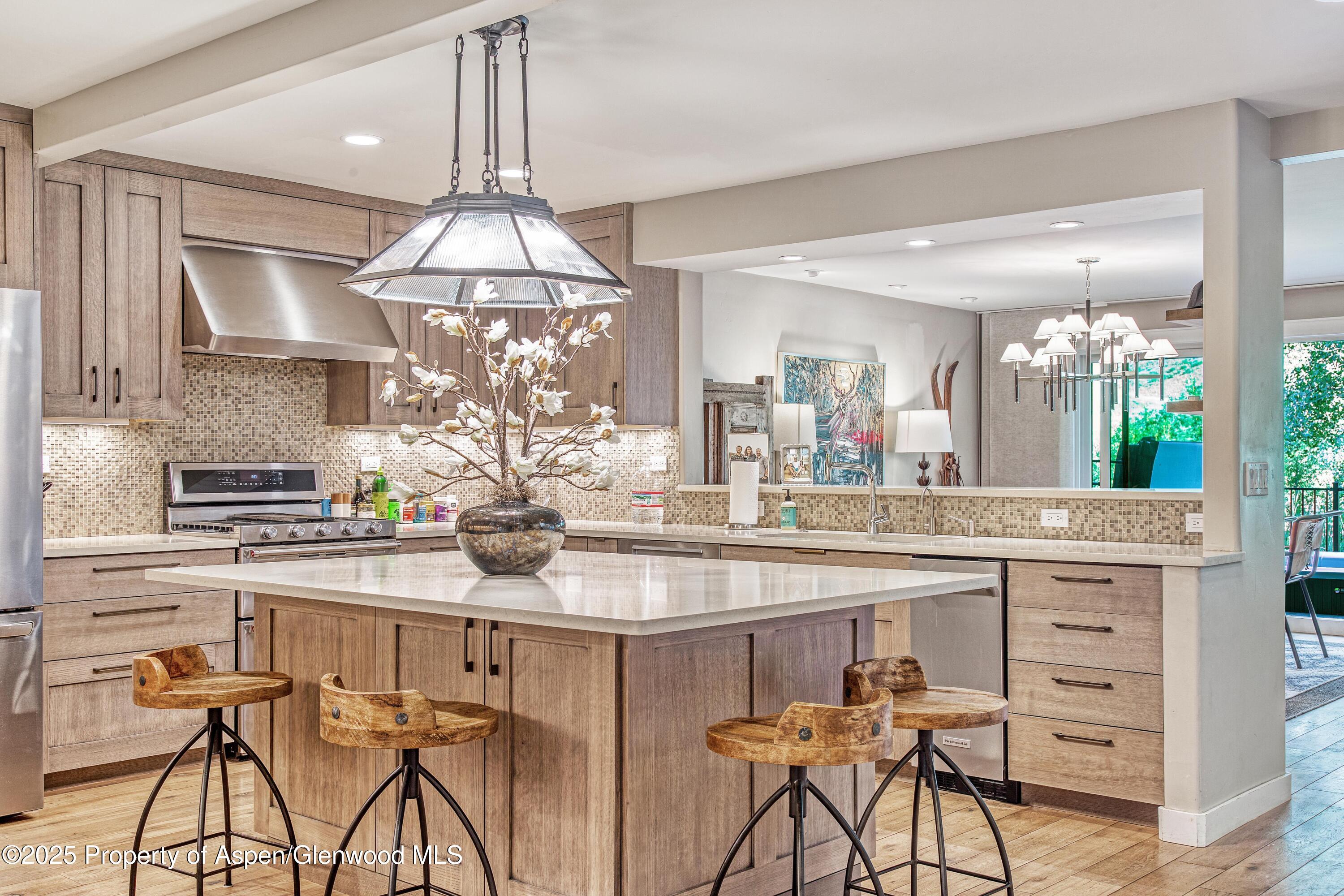 52 Harleston Green, Unit 38 Snowmass Village, CO 81615 - Photo 1 of 40 a kitchen with stainless steel appliances kitchen island a chandelier and cabinets