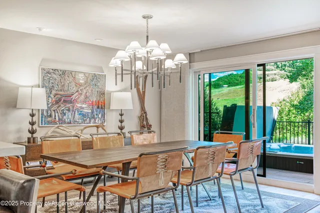 a dining room with furniture a chandelier and wooden floor