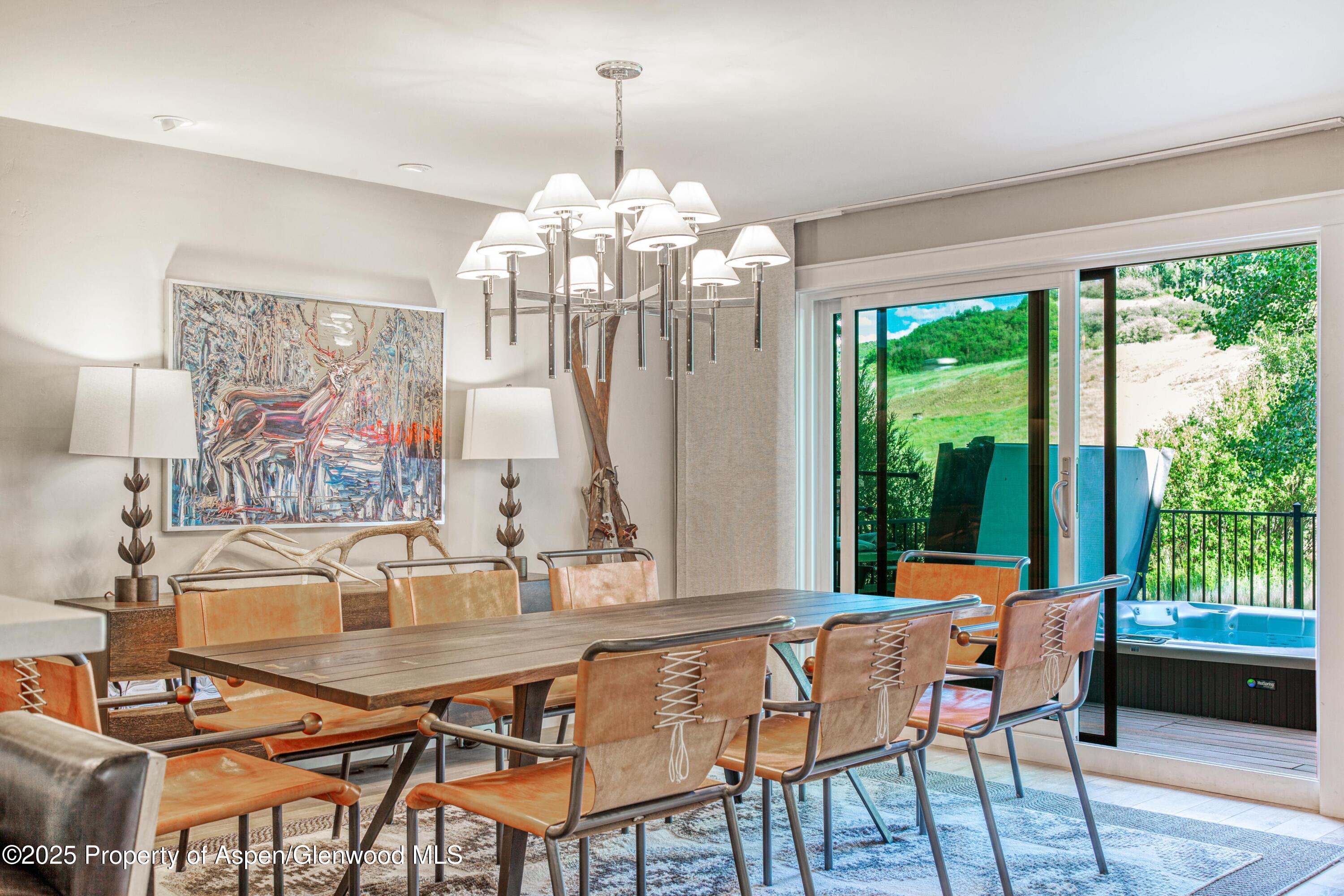52 Harleston Green, Unit 38 Snowmass Village, CO 81615 - Photo 13 of 40 a dining room with furniture a chandelier and wooden floor