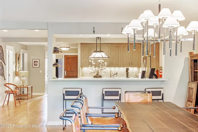 a room with chandelier fan and wooden floor