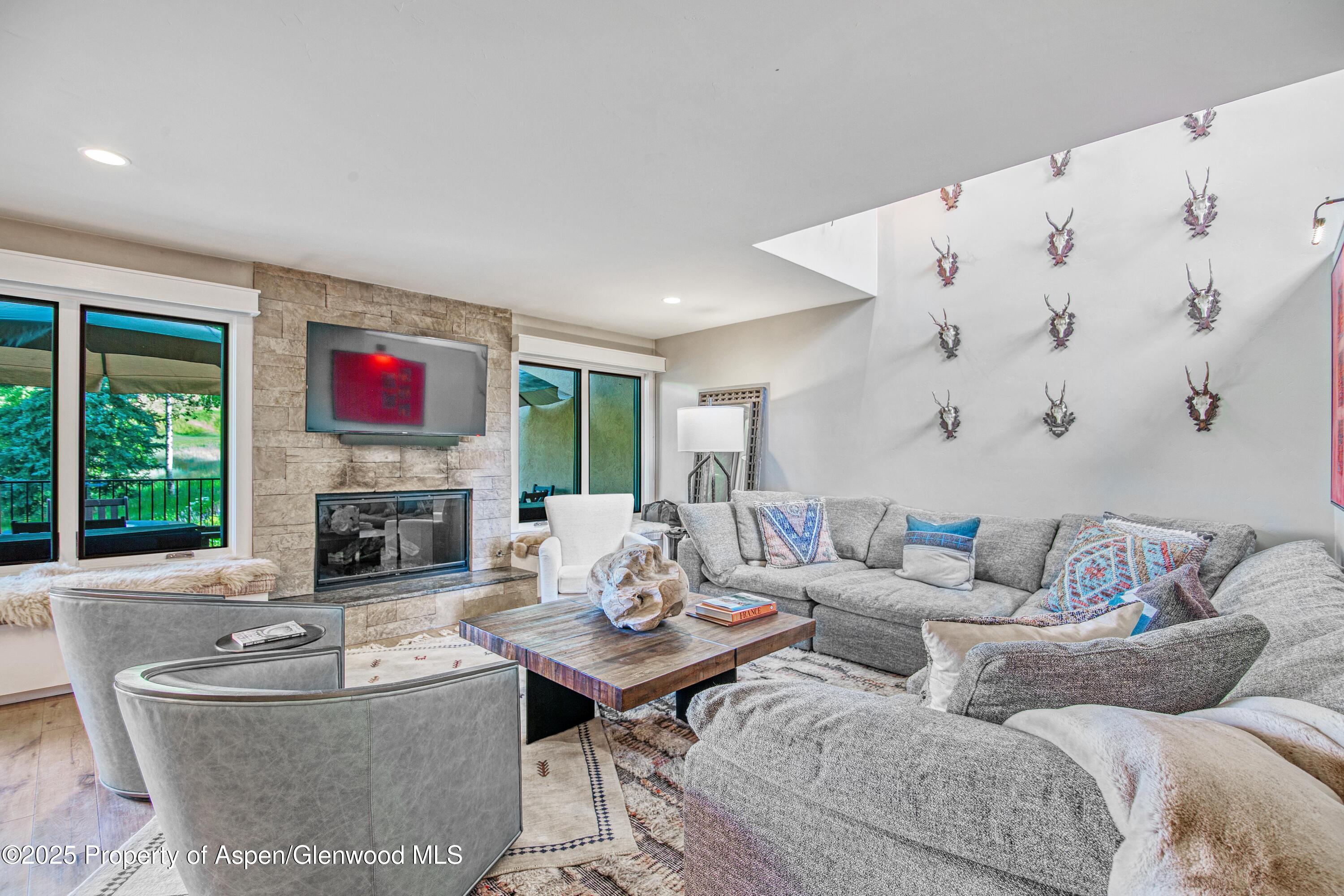 52 Harleston Green, Unit 38 Snowmass Village, CO 81615 - Photo 2 of 40 a living room with furniture and a fireplace