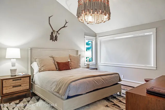 a bedroom with a bed and a chandelier