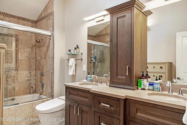 a bathroom with a double vanity sink toilet mirror and shower