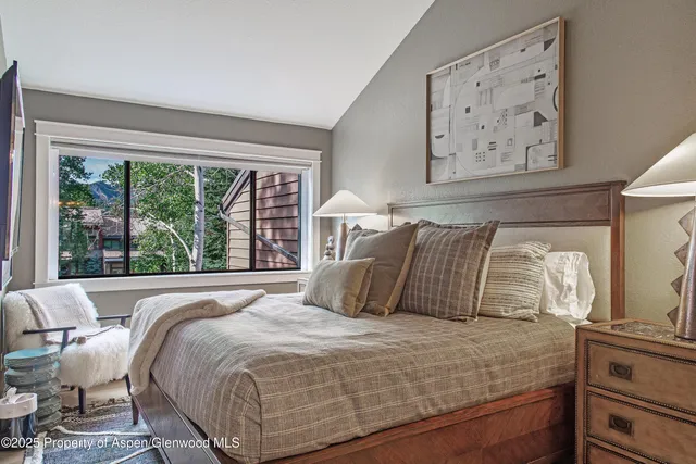 a bedroom with a large bed and a large window