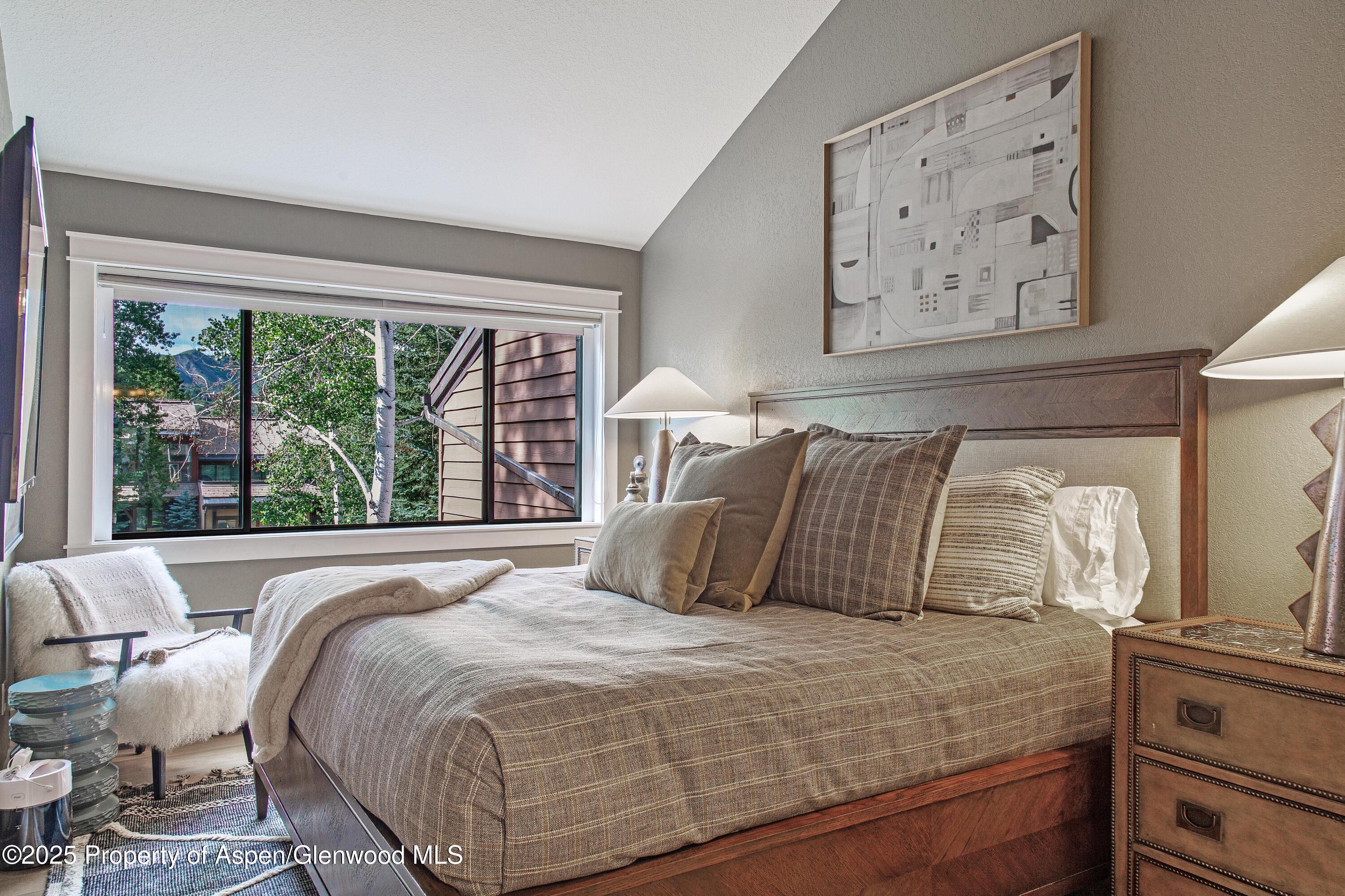 52 Harleston Green, Unit 38 Snowmass Village, CO 81615 - Photo 26 of 40 a bedroom with a large bed and a large window