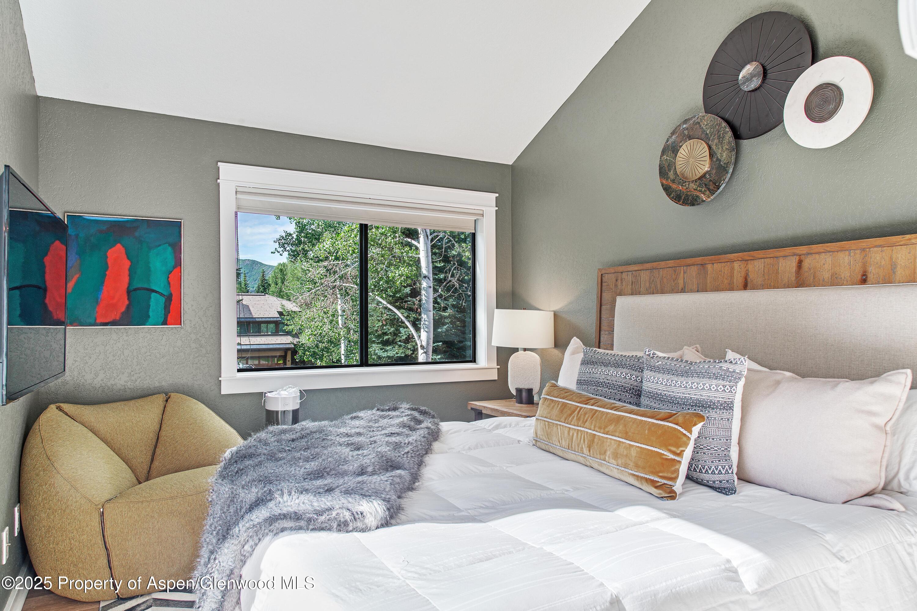 52 Harleston Green, Unit 38 Snowmass Village, CO 81615 - Photo 28 of 40 a bedroom with a bed and a large window