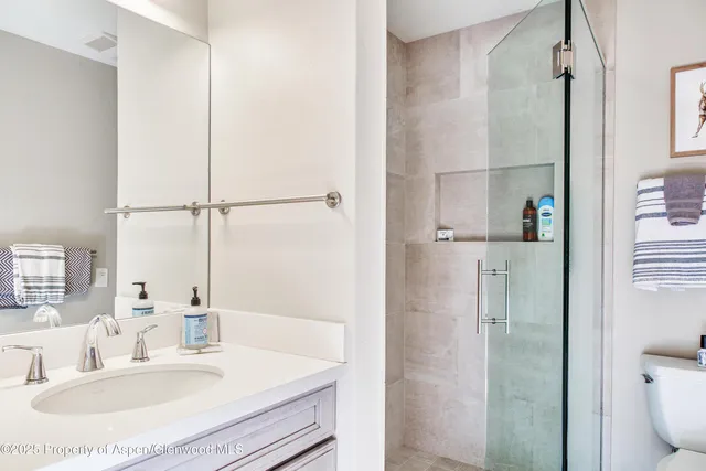 a bathroom with a sink toilet and shower