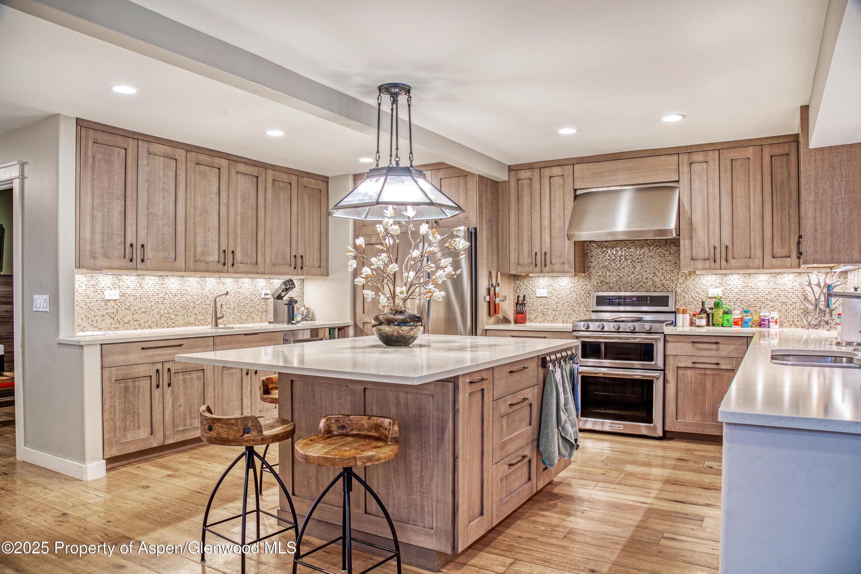 52 Harleston Green, Unit 38 Snowmass Village, CO 81615 - Photo 3 of 40 a kitchen with stainless steel appliances granite countertop a stove top oven a sink dishwasher and a refrigerator