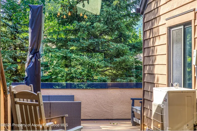 a view of a brick wall with a tree in front of it