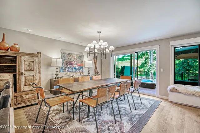 a dining room with furniture a chandelier and wooden floor