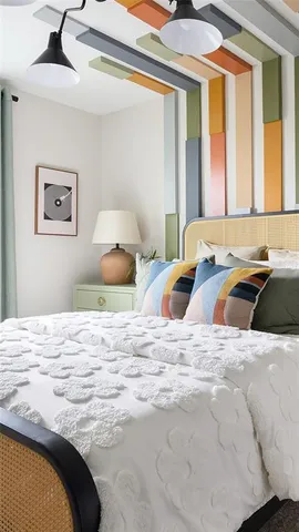 a bedroom with a bed and a painting on the wall