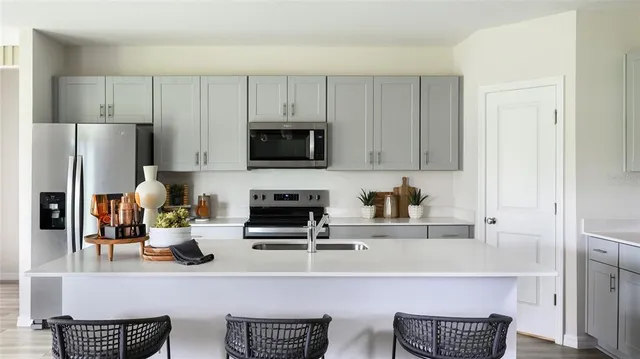 a kitchen with stainless steel appliances a stove a sink a refrigerator and cabinets