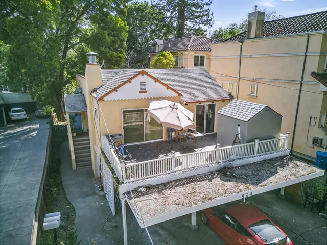 a view of a house with a deck and furniture