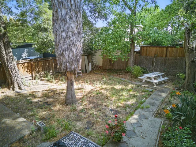 a backyard of a house with table and chairs