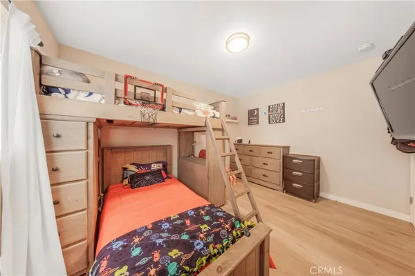 a room with a baby bed dresser and a window
