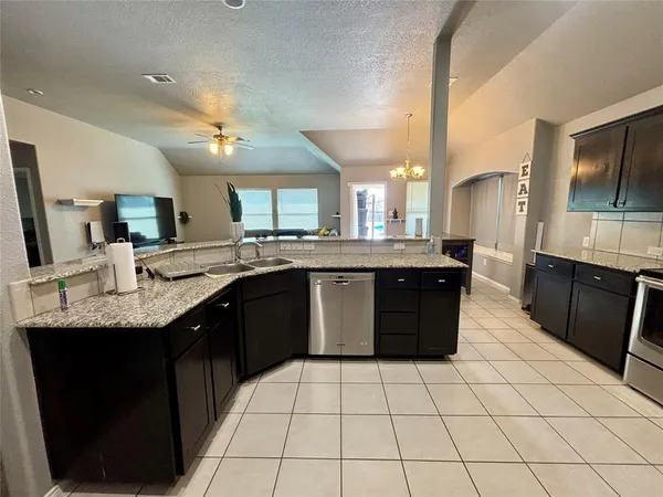 a kitchen with a sink a counter top space cabinets and stainless steel appliances