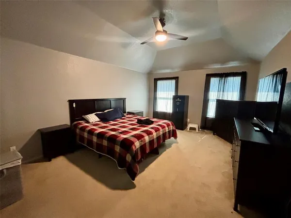 a bedroom with a bed and dresser with mirror