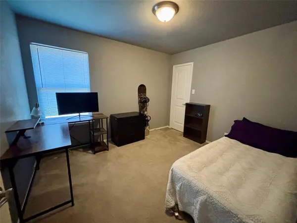 a bedroom with a bed and a computer on a table