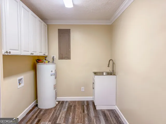 a utility room with wooden floor washer and dryer