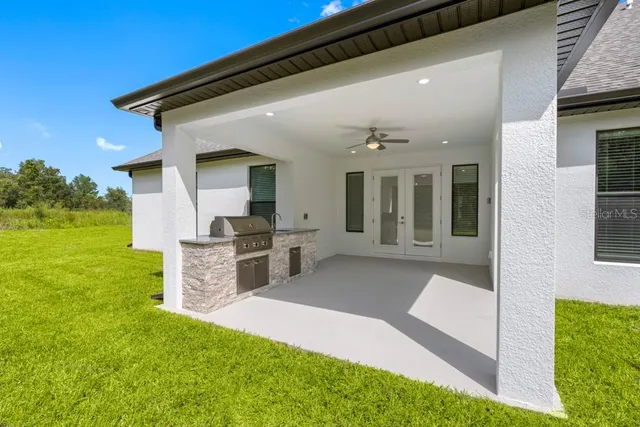 a large kitchen with stainless steel appliances kitchen island a large counter top and a wooden floors