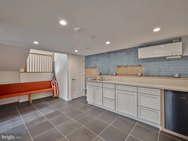 a view of a kitchen with white cabinets