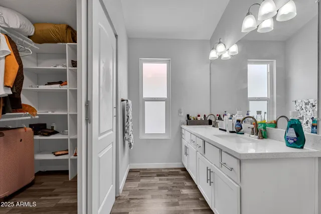 a bathroom with a double vanity sink a mirror and a bathtub