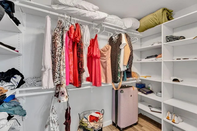 a view of walk in closet with clothes and shoes
