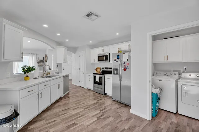 a kitchen with cabinets and wooden floor