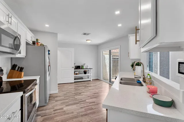 a kitchen with stainless steel appliances a sink a stove and refrigerator