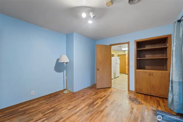 a view of empty room with wooden floor