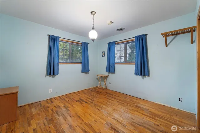 a view of a room with wooden floor and windows
